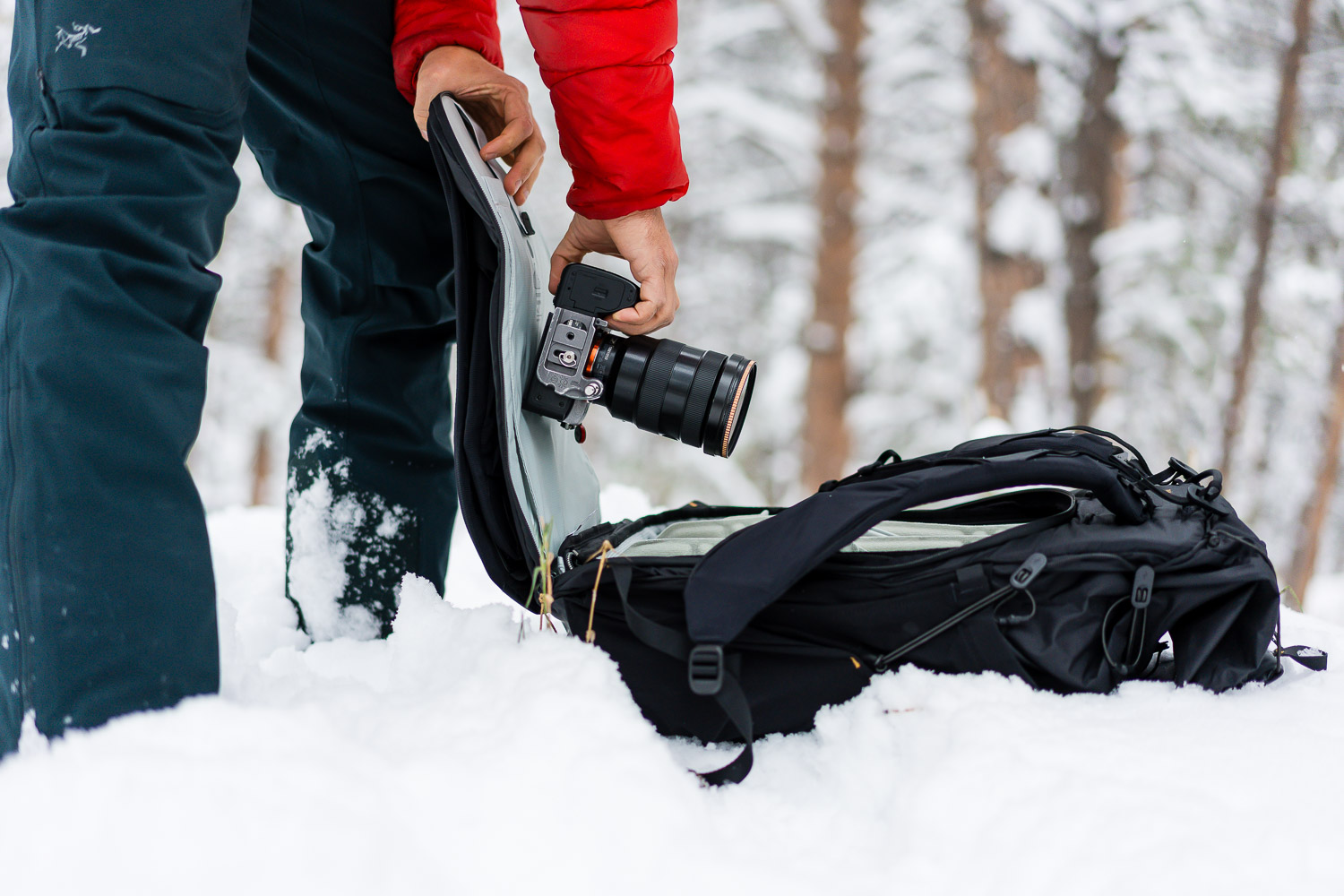 peak design outdoor backpack 45l in the snow with the zipper pocket open